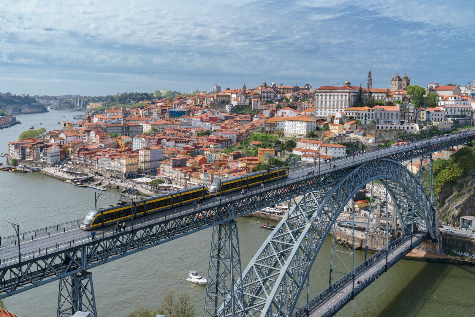 A tram crossing the Luís I Bridge in Porto — Portugal's SNS enrolls legal residents with no medical underwriting, which makes it the #1 pick for this profile. Photo: Pexels.
